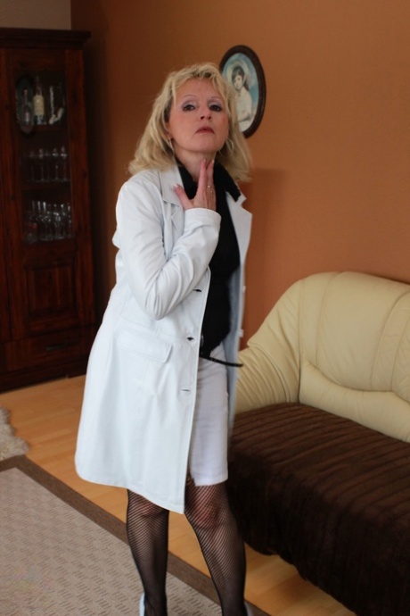 Mature blonde Beate disrobes for solo couch masturbation with big dildo