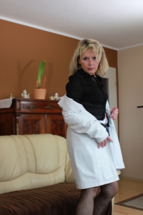 Mature blonde Beate disrobes for solo couch masturbation with big dildo